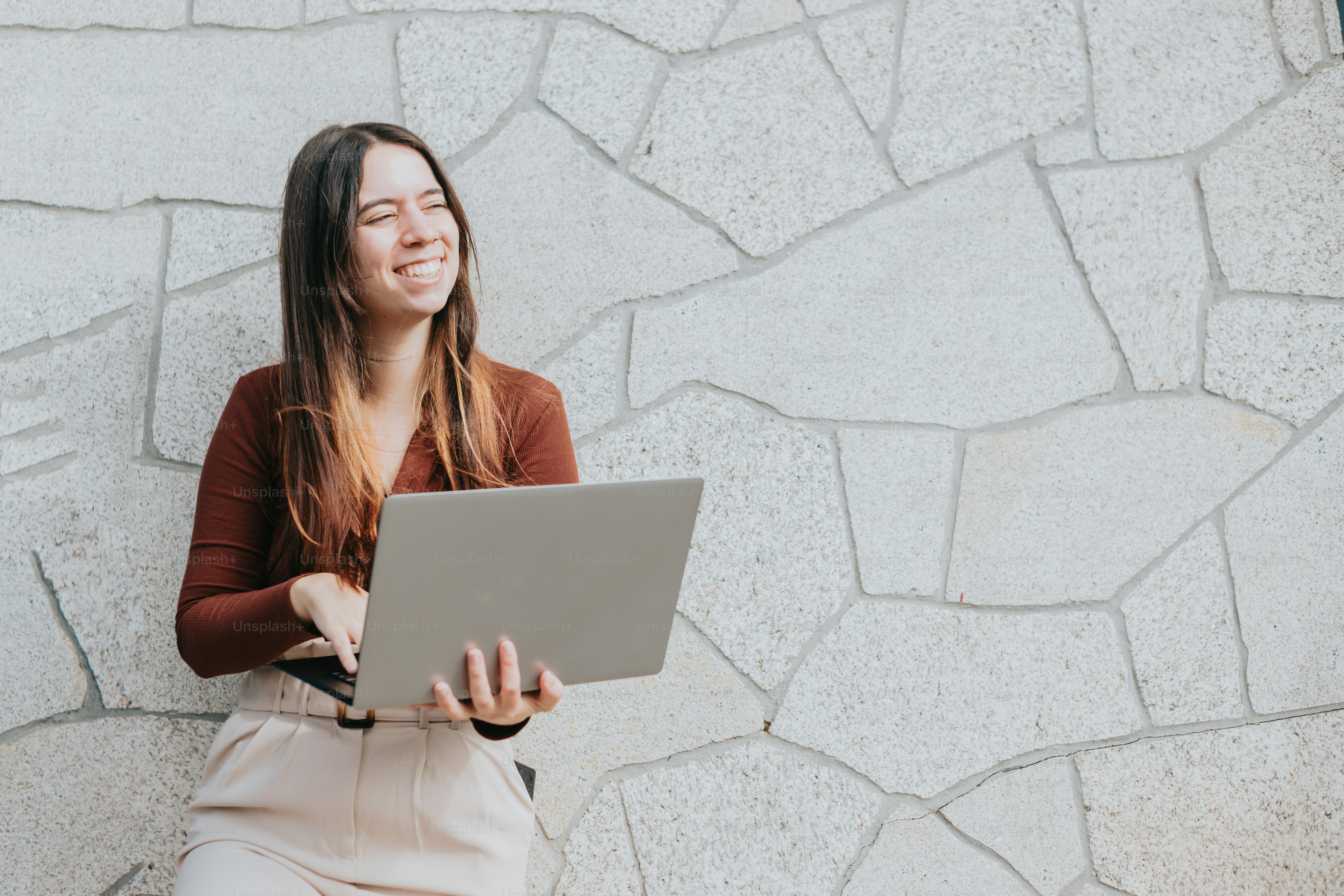uma mulher sentada em um banco usando um computador portátil
