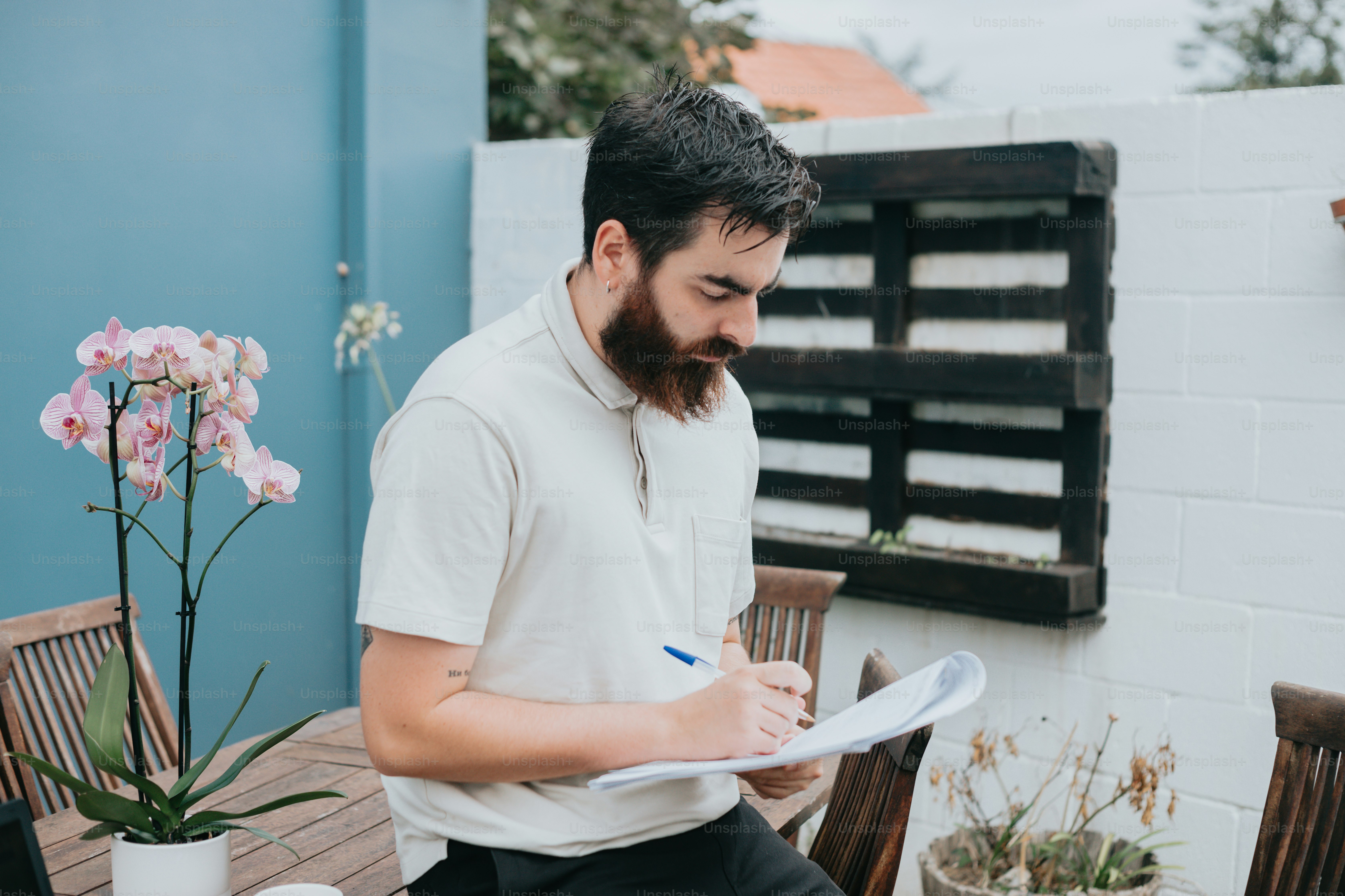 Un homme assis à une table écrivant sur un morceau de papier