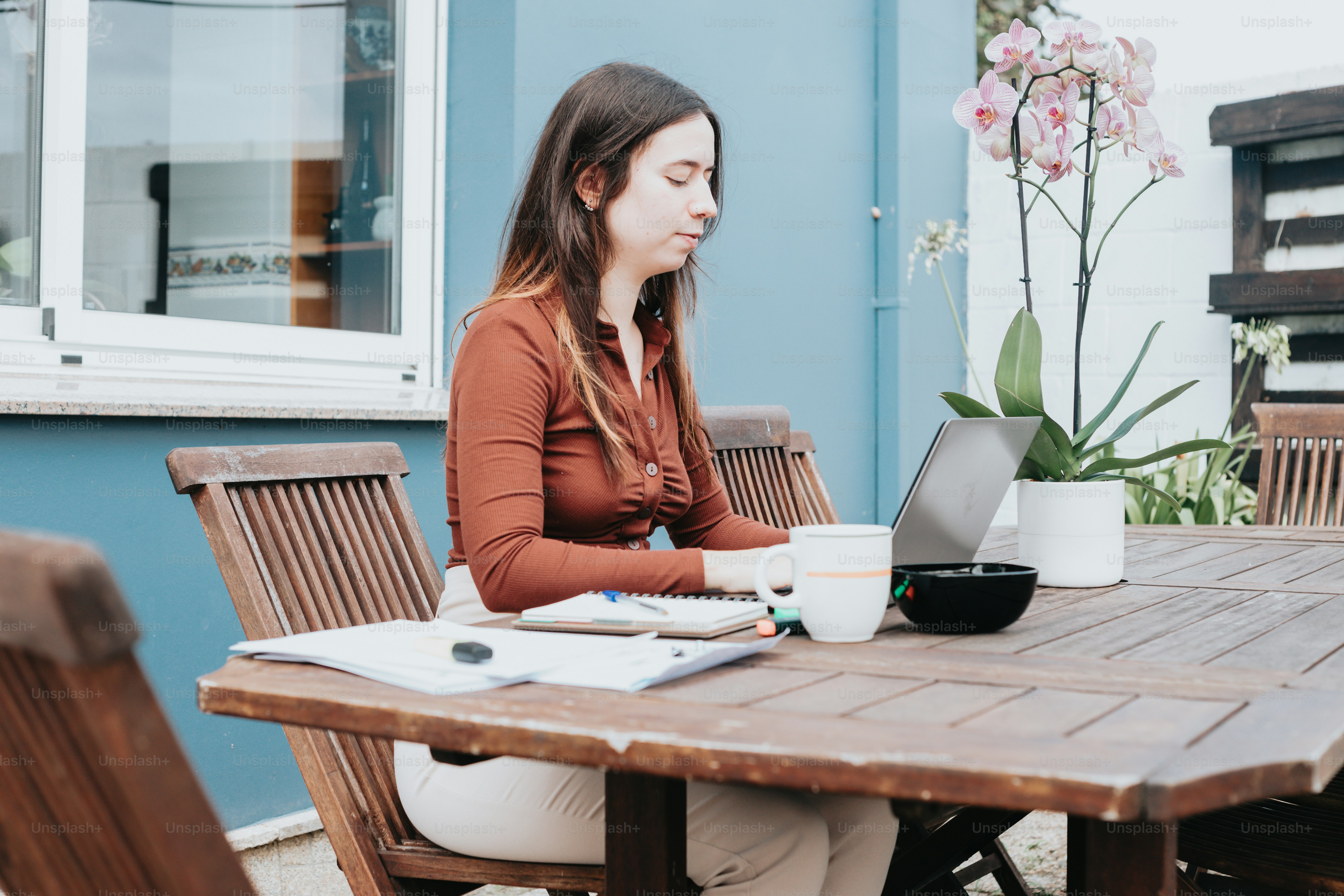 Une femme assise à une table avec un ordinateur portable