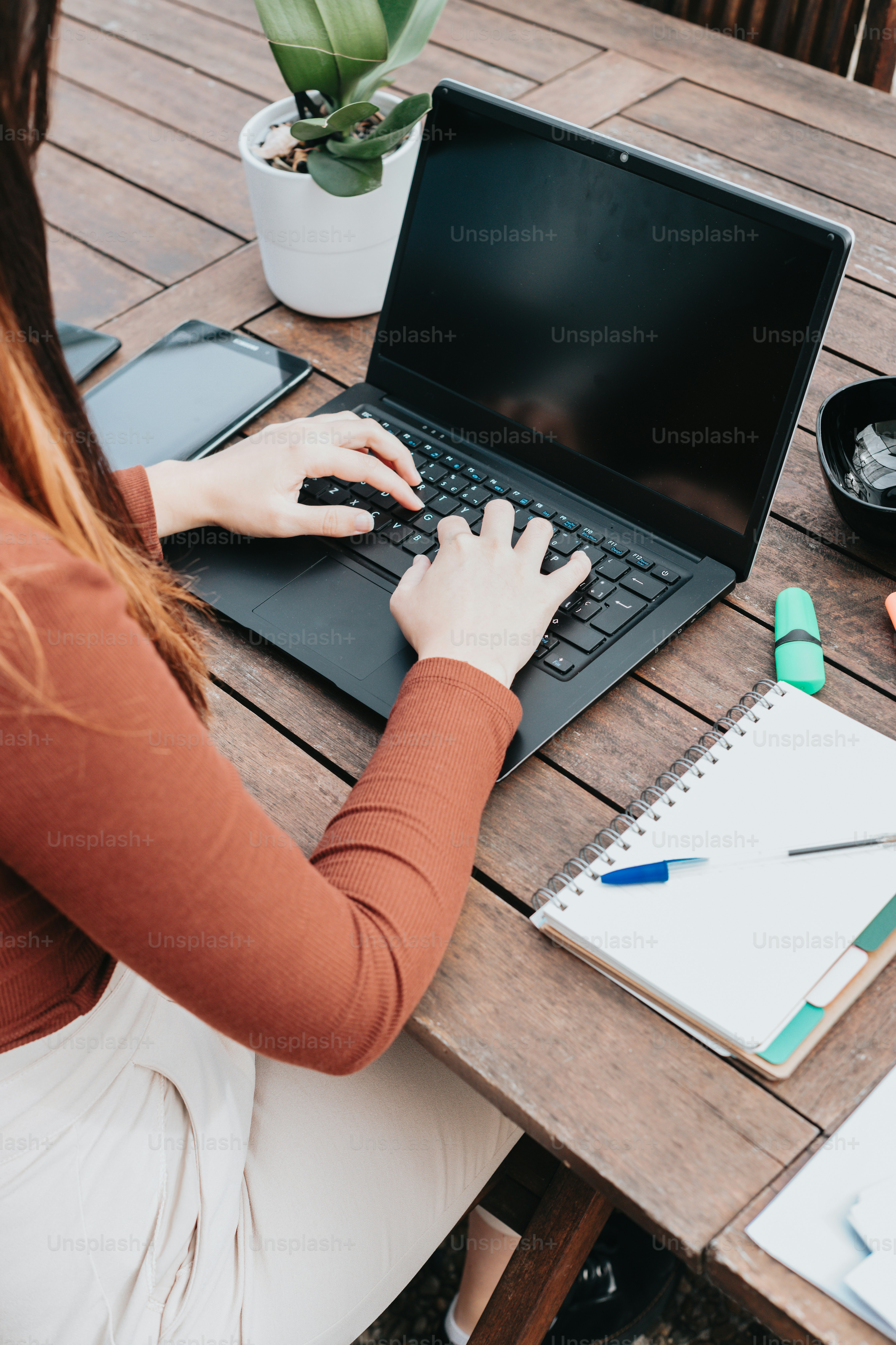 uma mulher sentada em uma mesa usando um computador portátil