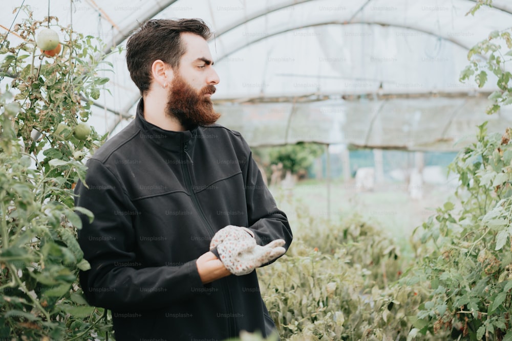 a man holding a glove in a greenhouse