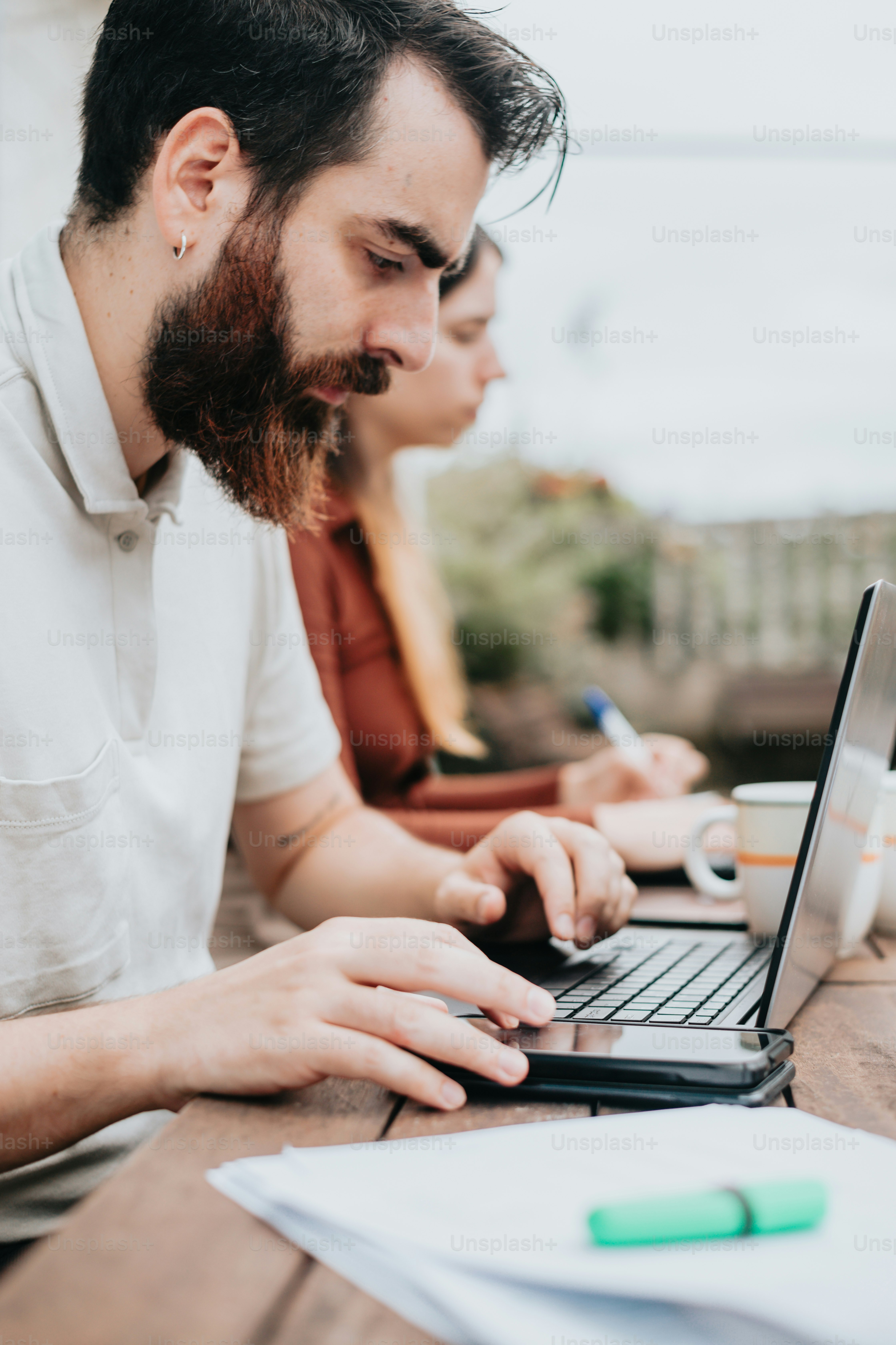 a man sitting at a table using a laptop computer