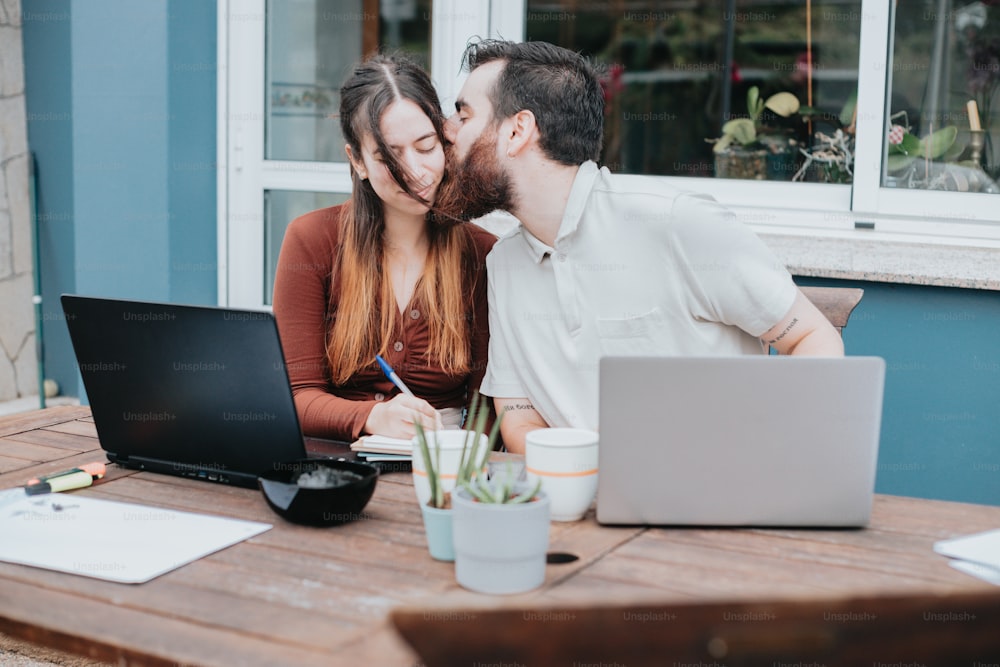 um homem e uma mulher se beijando na frente de um laptop