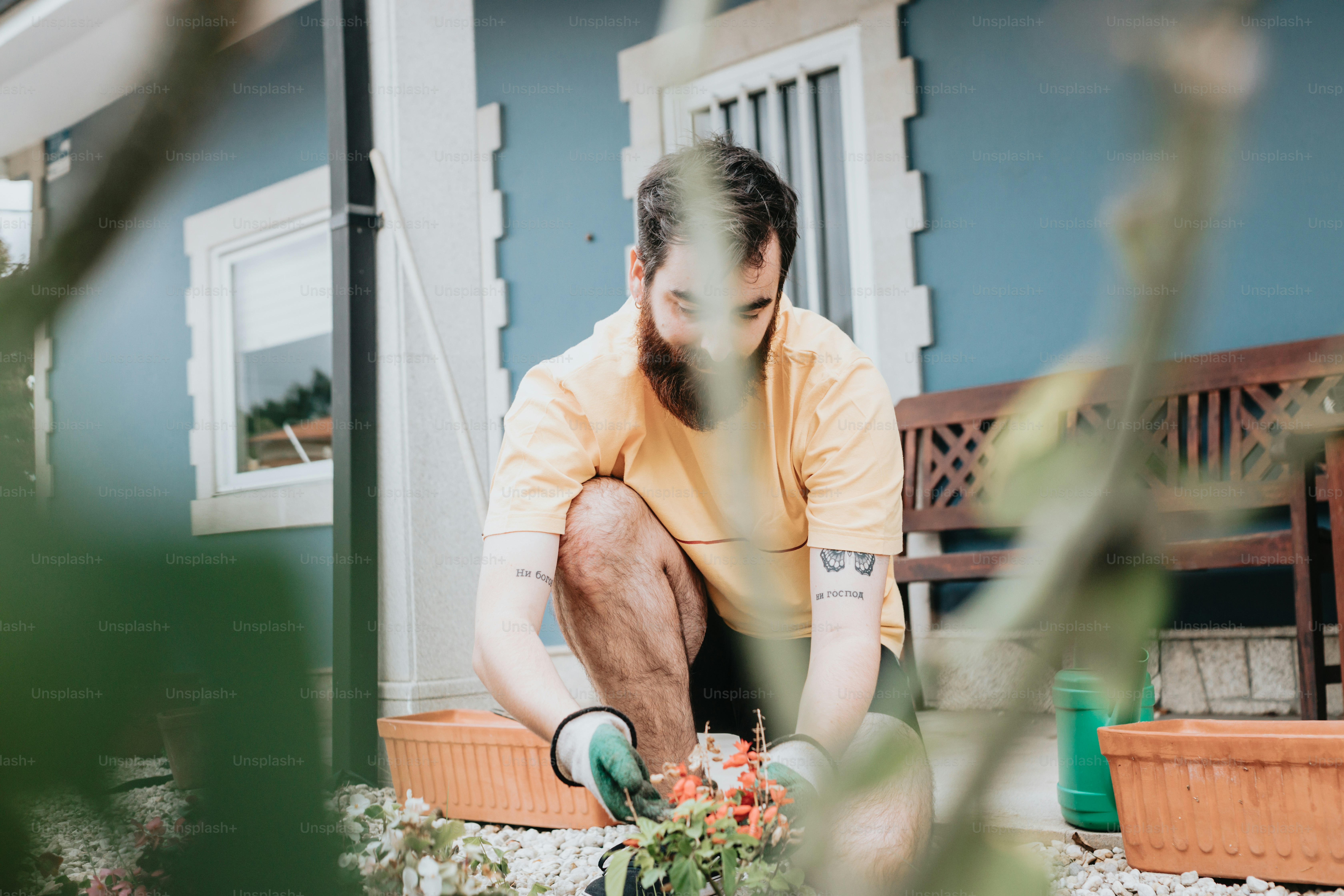 a man in a yellow shirt is gardening