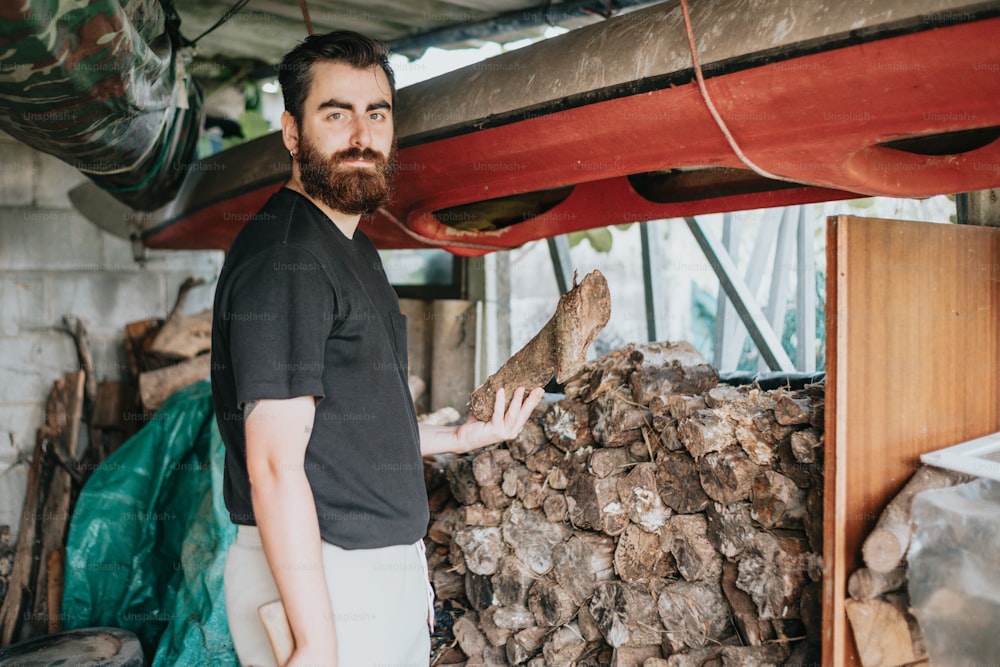 a man standing next to a pile of wood