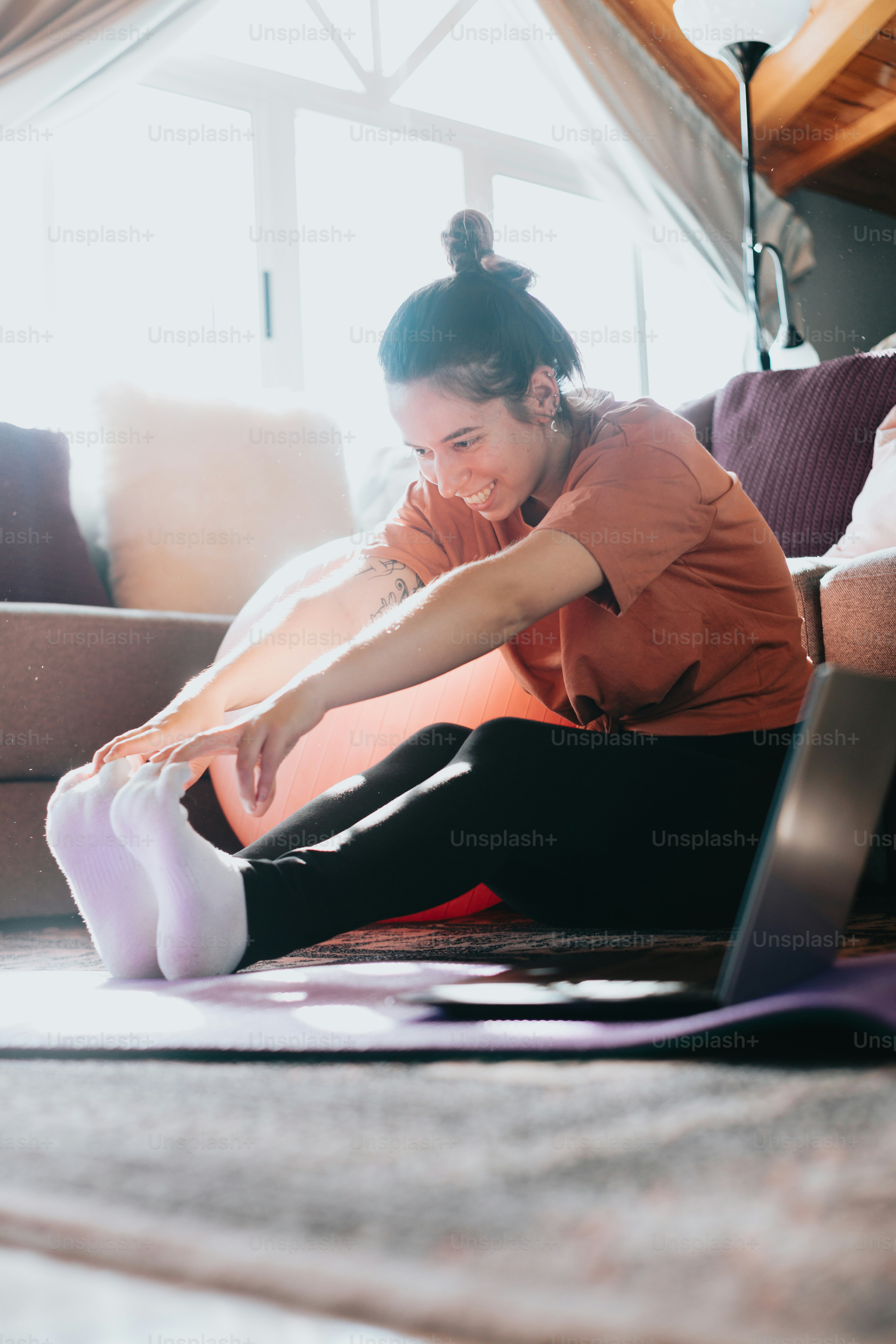 a woman sitting on the floor using a laptop