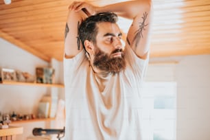 a man with a beard and tattoos on his arms