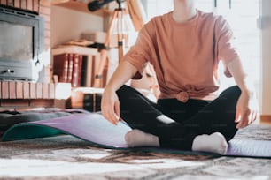 a person sitting on a yoga mat in a living room