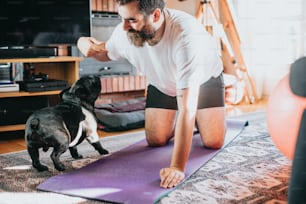 Un hombre está haciendo yoga con su perro