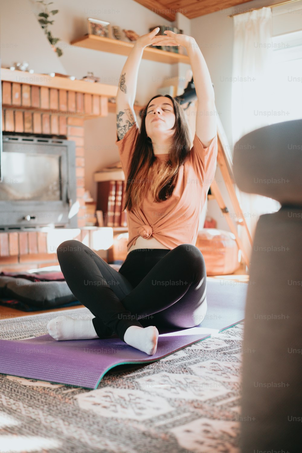 Una mujer sentada encima de una esterilla de yoga