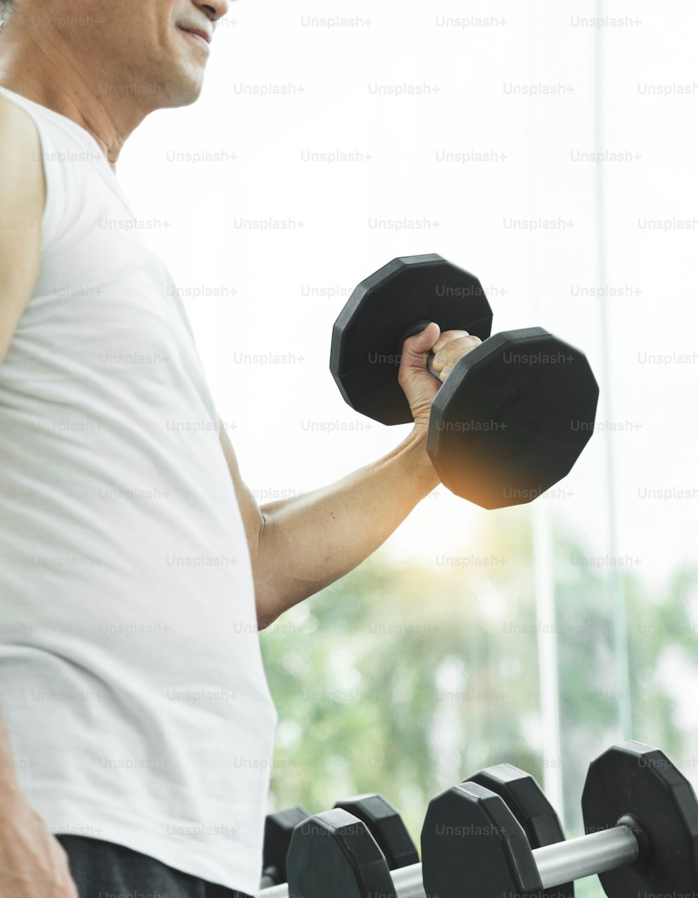 Asian senior man  lifting dumbbells in gym. copy space.