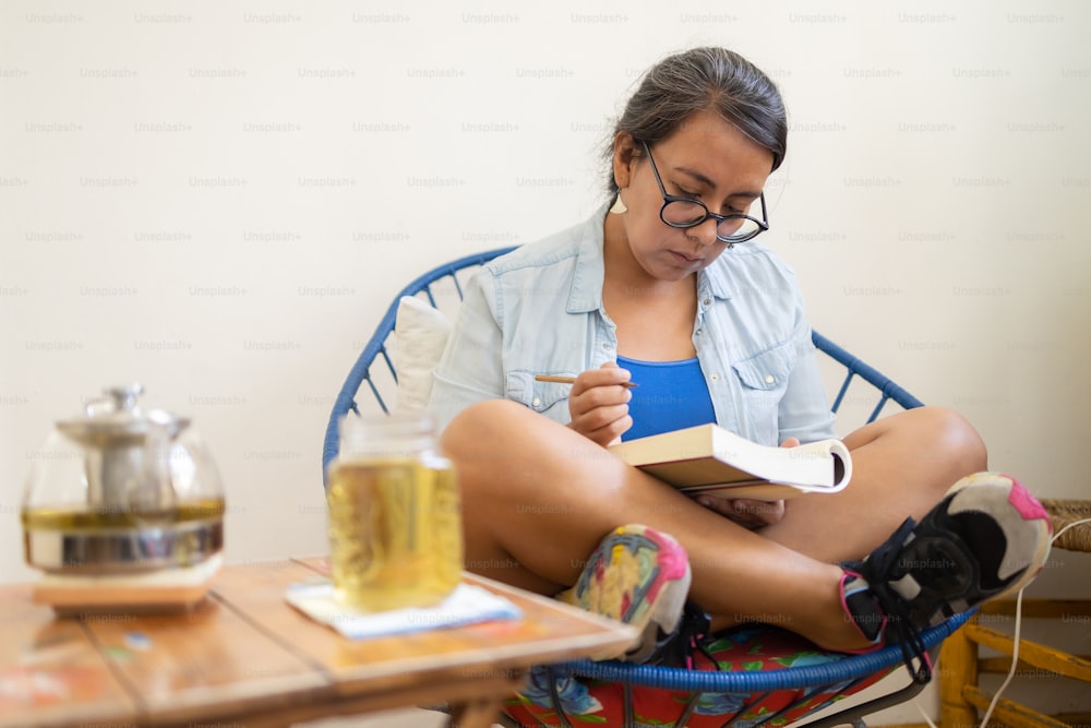 Mexikanische tätowierte Millennial-Frau, die ein Buch liest