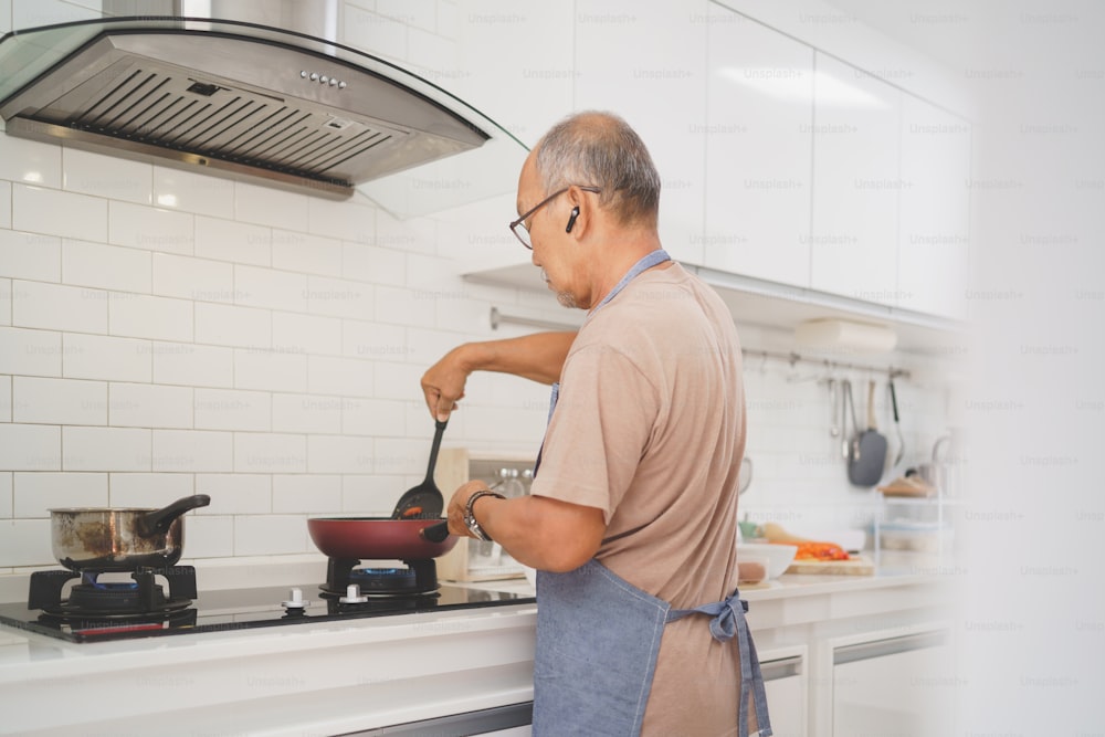 Asiatique senior homme cuisine dans la cuisine, nourriture saine
