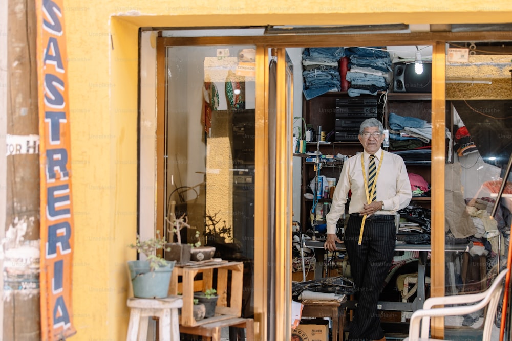 Retrato de um alfaiate mexicano velho que trabalha com a máquina de costura