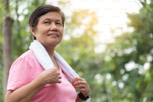 Portrait of Asian smiling sporty senior woman in a park outdoor.