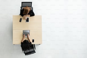 Top view of Asian Businesswomen using laptop and digital tablet computer on their workplace at the office. Copy space.