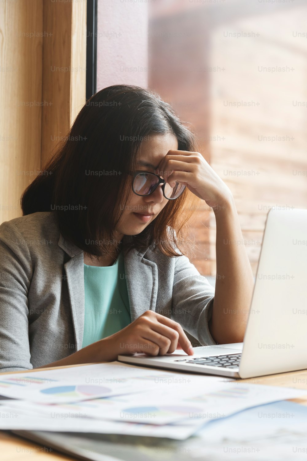 Asian Business woman with laptop  thinking about her work at her workplace.