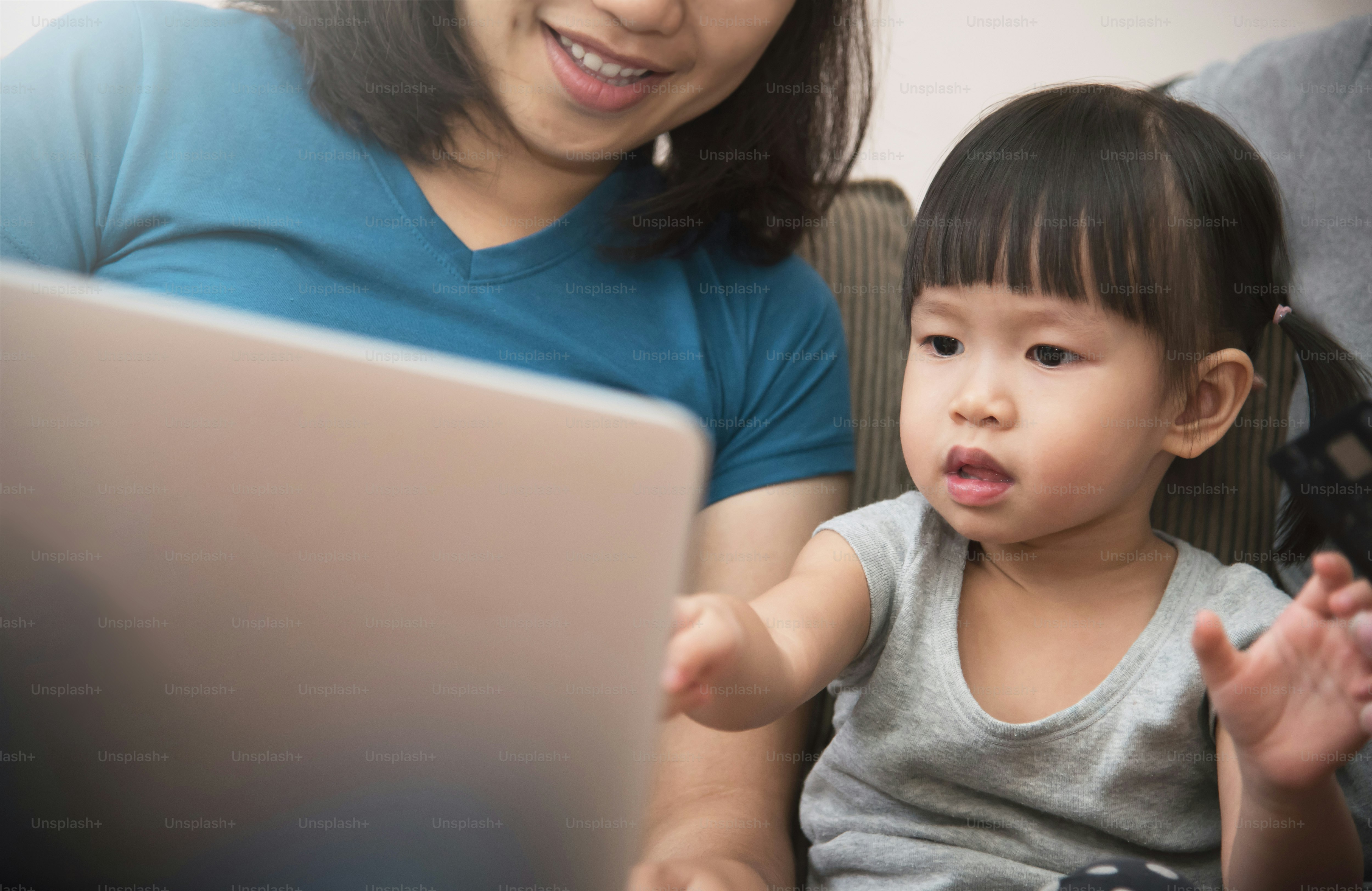 Happiness of Asian  family sitting and using laptop together with technology. Smiling of Young father and mother with little kid girl. Knowledge and Learning concept.