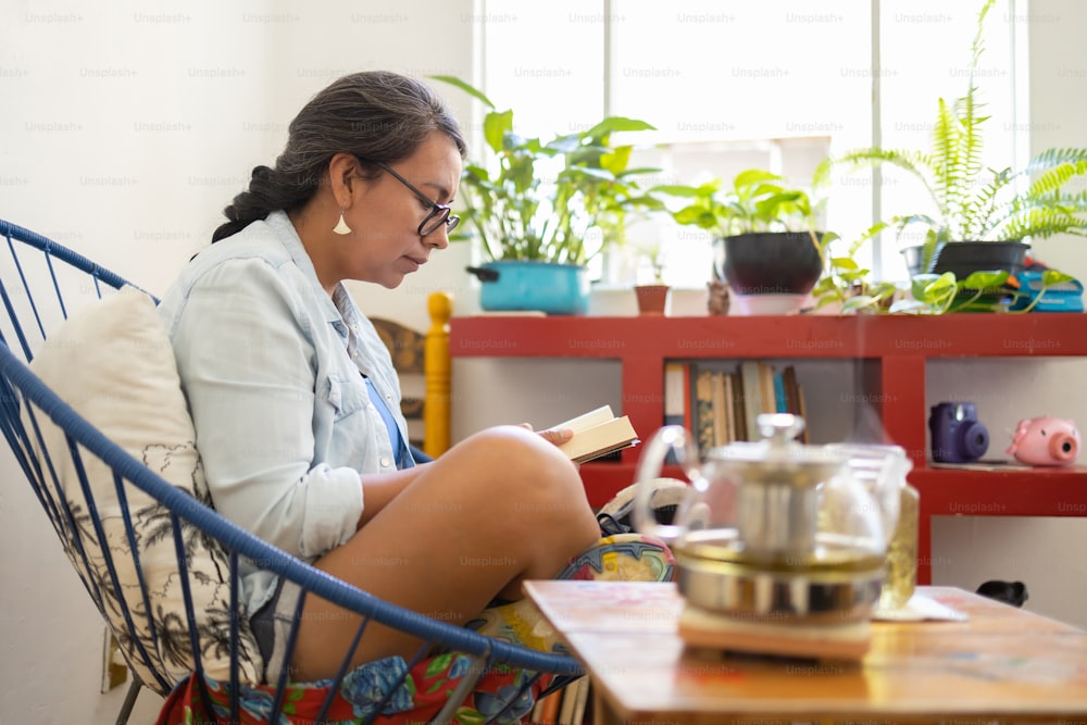 Mexikanische tätowierte Millennial-Frau, die ein Buch liest