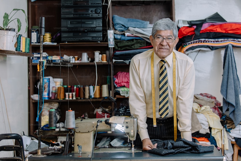 Retrato de um alfaiate mexicano velho que trabalha com a máquina de costura