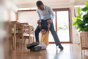 African American Father and his little son playing on the floor at home together.