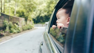 Petit garçon enfant asiatique regardant par la fenêtre de la voiture pendant le voyage en voiture, voyage en voiture, voyage en voiture, vacances d’été
