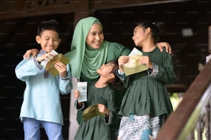 Familia musulmana, los niños recibieron un paquete de dinero como bendición, concepto de Hari Raya Eid Al-Fitr.