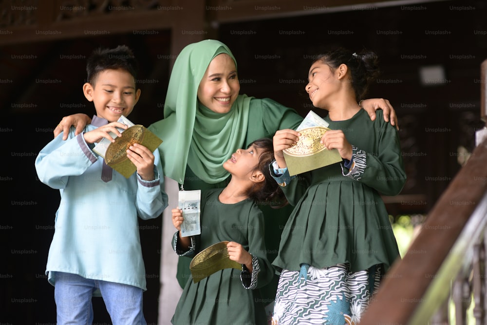 Muslimische Familie, Kinder erhielten Geldpaket als Segen, Hari Raya Eid Al-Fitr Konzept.
