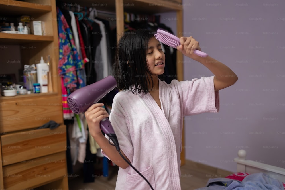 mexican teenage girl getting her hair dry after shower