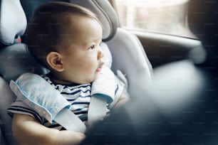카시트에 앉은 행복한 아시아 아기, 가족과 함께 차로 여행하는 어린 아이.