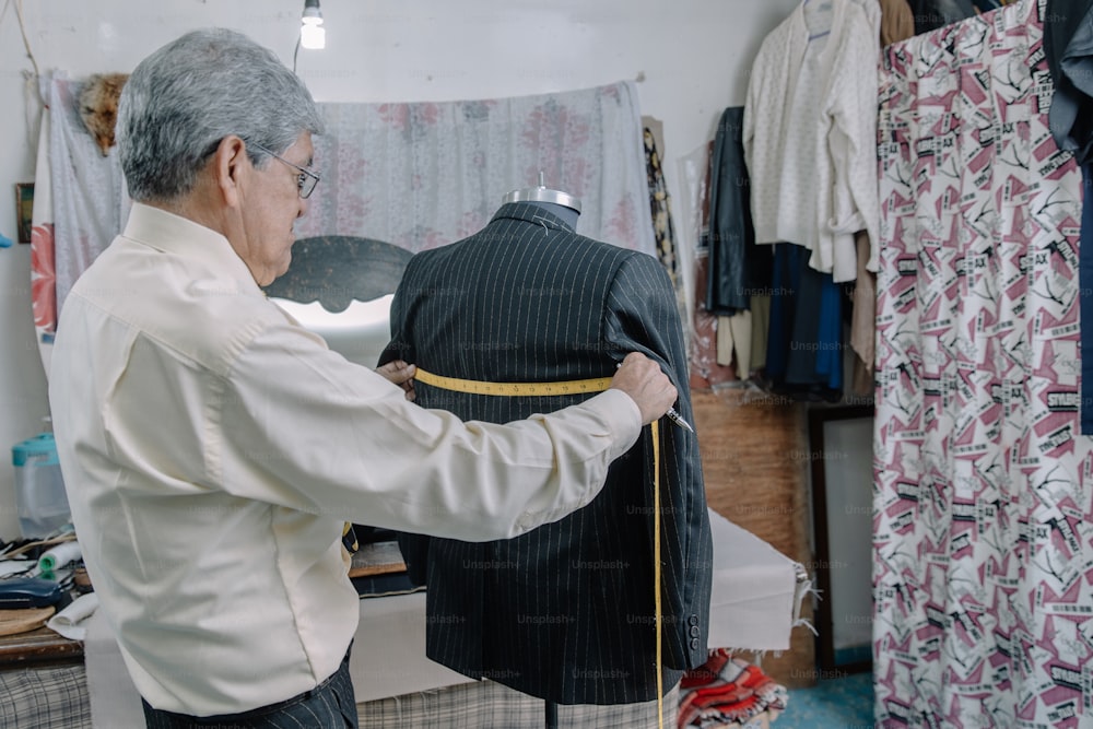 Mexican tailor taking measurements in his workshop