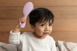 Mexican baby combing after shower on bedroom