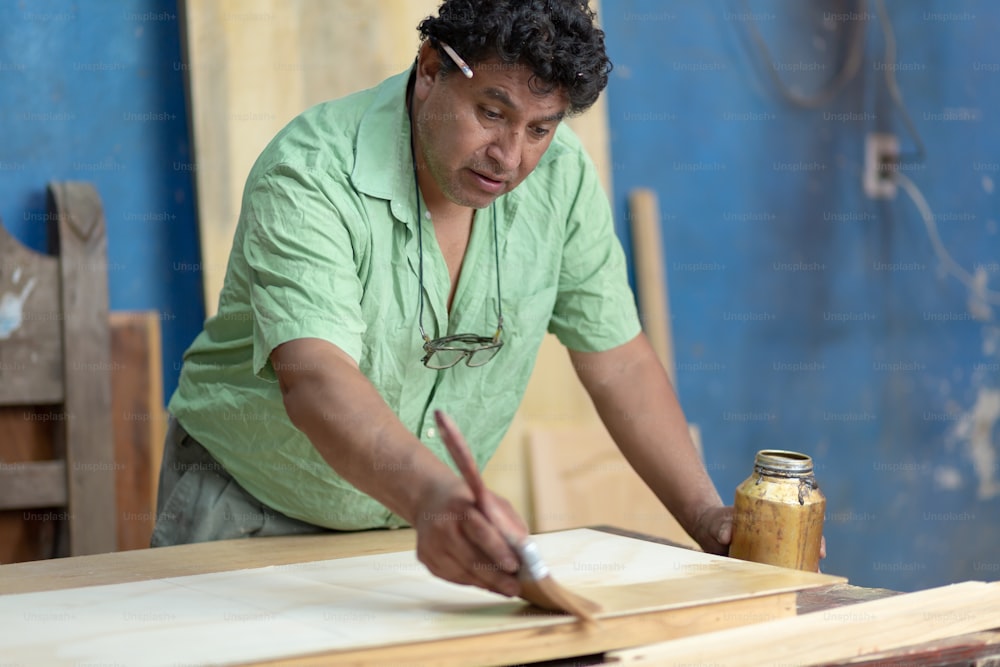 Carpintero mexicano, carpintero barnizando en su taller