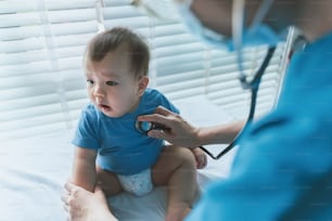 Pediatra asiático com bebê paciente em clínica pediátrica, Médico usando estetoscópio para verificar batimentos cardíacos e pulmões, Exame médico