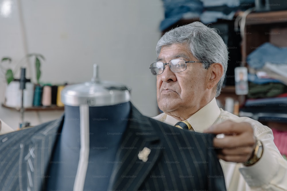 Aged Mexican tailor taking measurements in his workshop