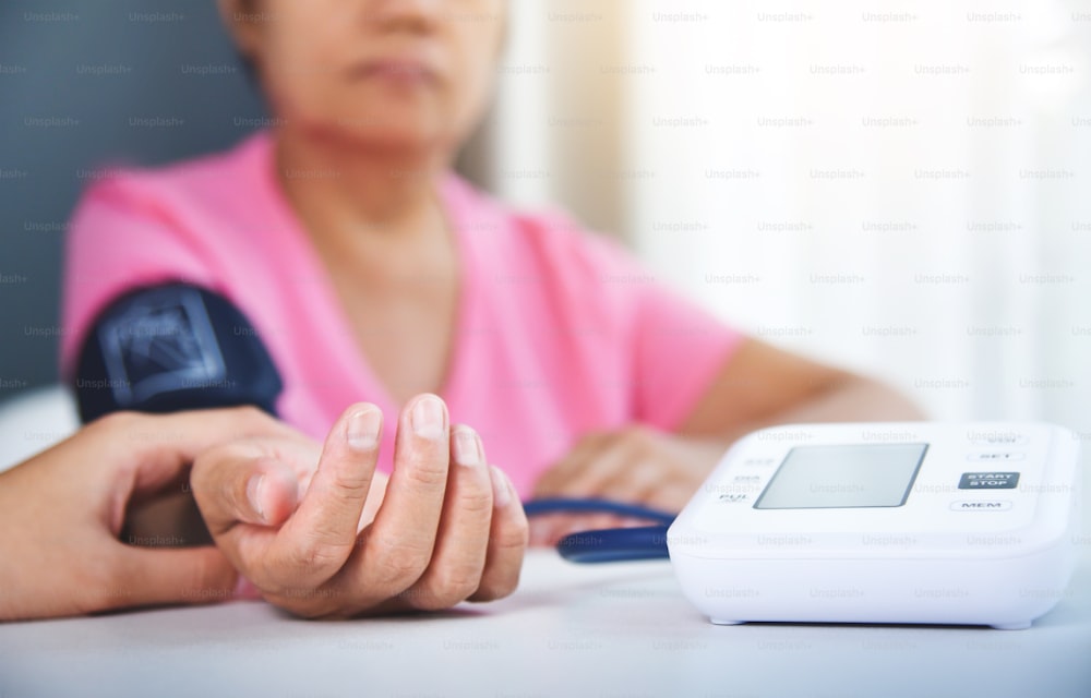 高齢の女性患者の脈拍をチェックするアジアの女性医師。医療。血圧。
