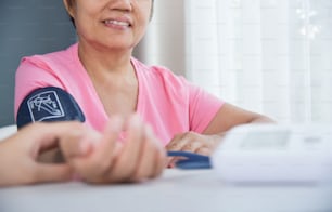 아시아 여성 의사가 노인 여성 환자 맥박을 확인하고 있다. 의료. 혈압.