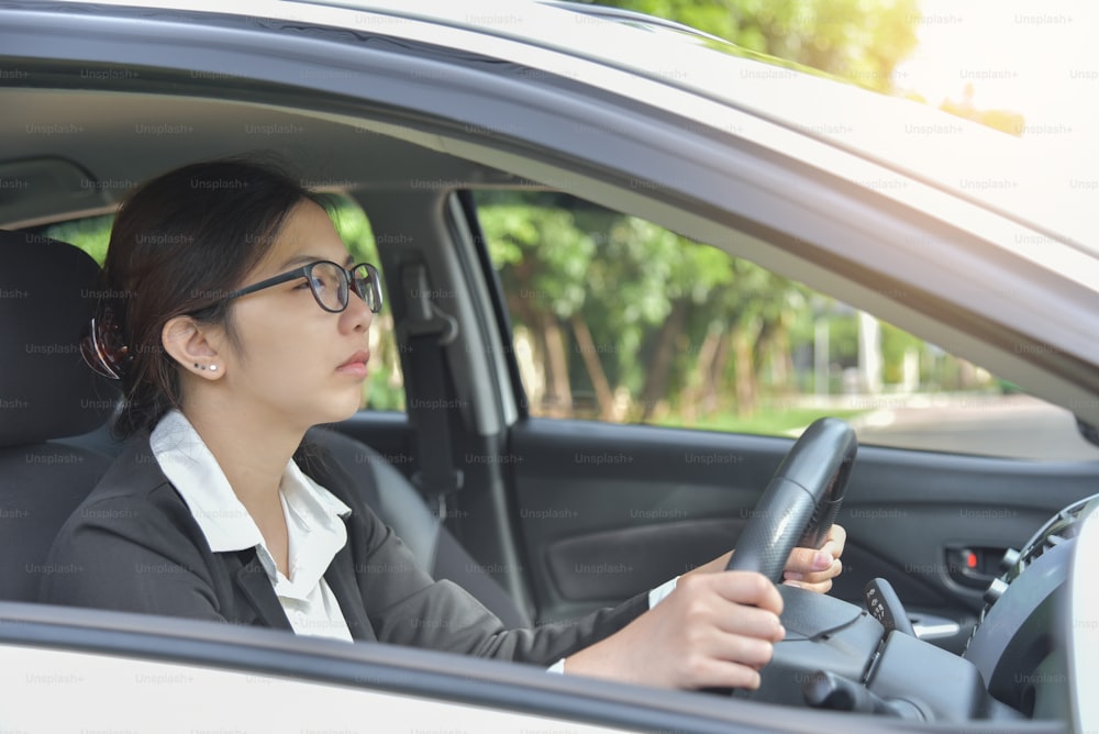 Tired Sleepy Asian glasses Business woman driving a car. Illness, exhausted, disease, for overtime working concept.