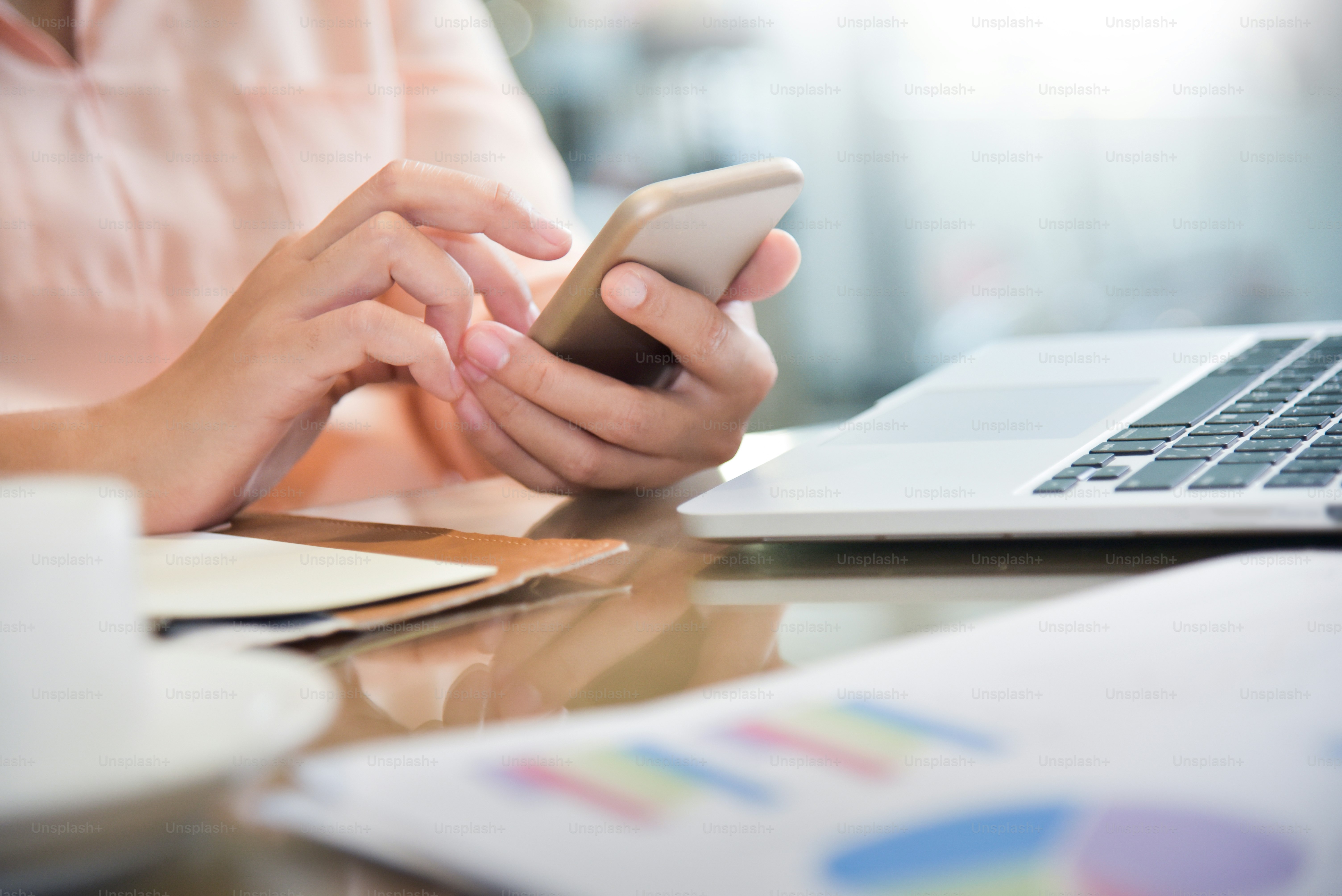 젊은 아시아 여성은 직장에서 휴대폰을 사용하고 있다. 집에서 스마트폰으로 온라인 쇼핑을 하는 여자. 랩톱.