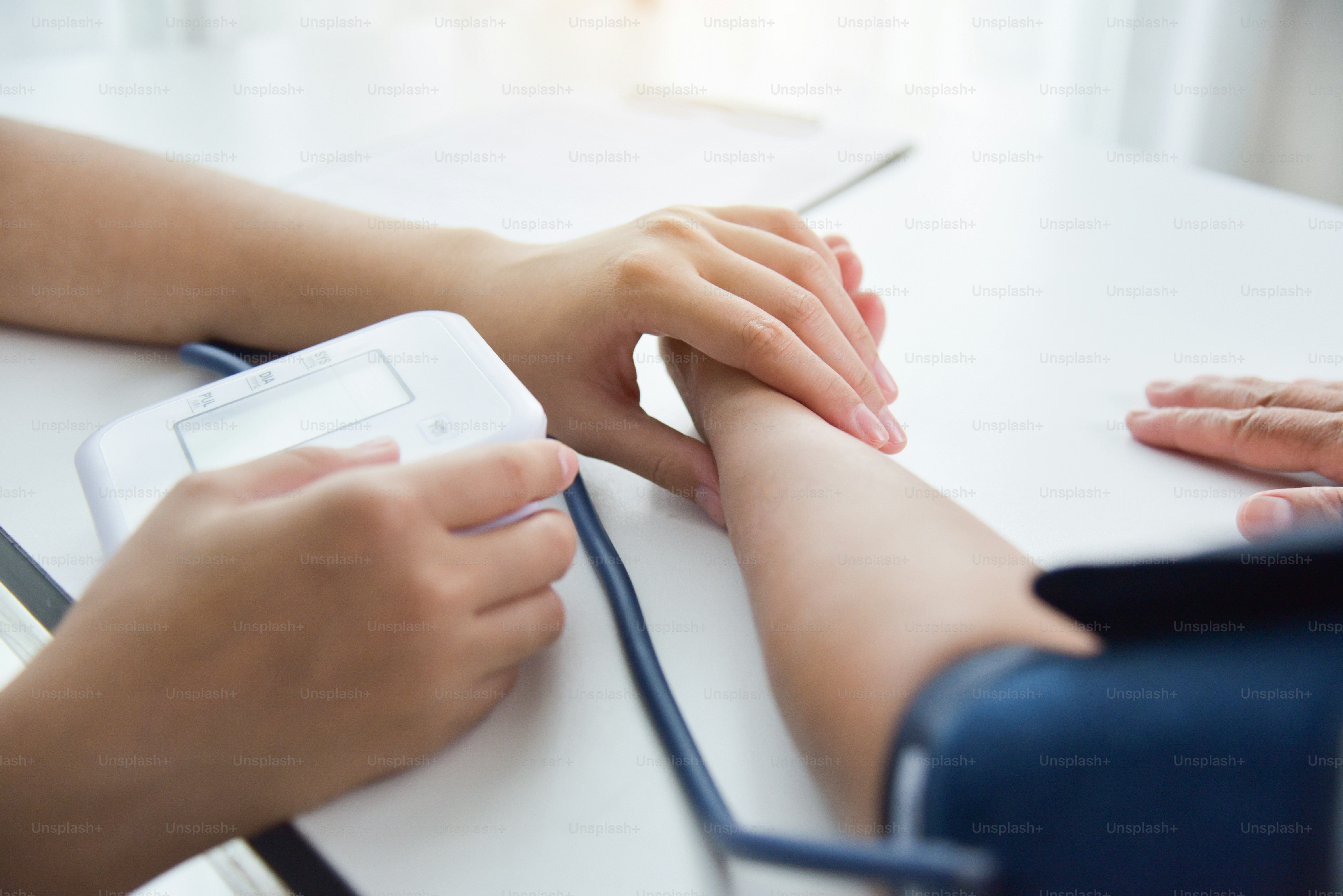Asian Female doctor checking a senior woman patient pulse. Health care.
