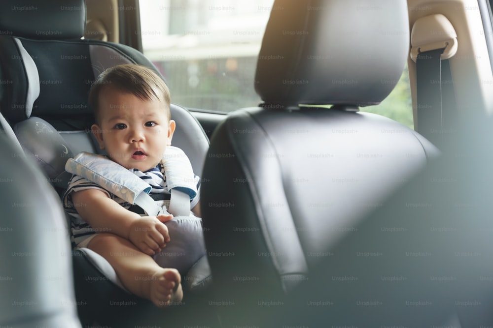 안전 카시트에 사랑스러운 작은 아시아 아기, 가족과 함께 자동차로 여행하는 행복한 작은 유아.