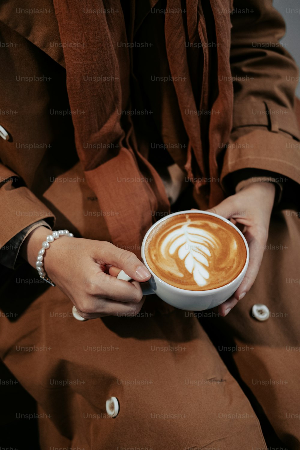 eine Person, die eine Tasse Kaffee in den Händen hält