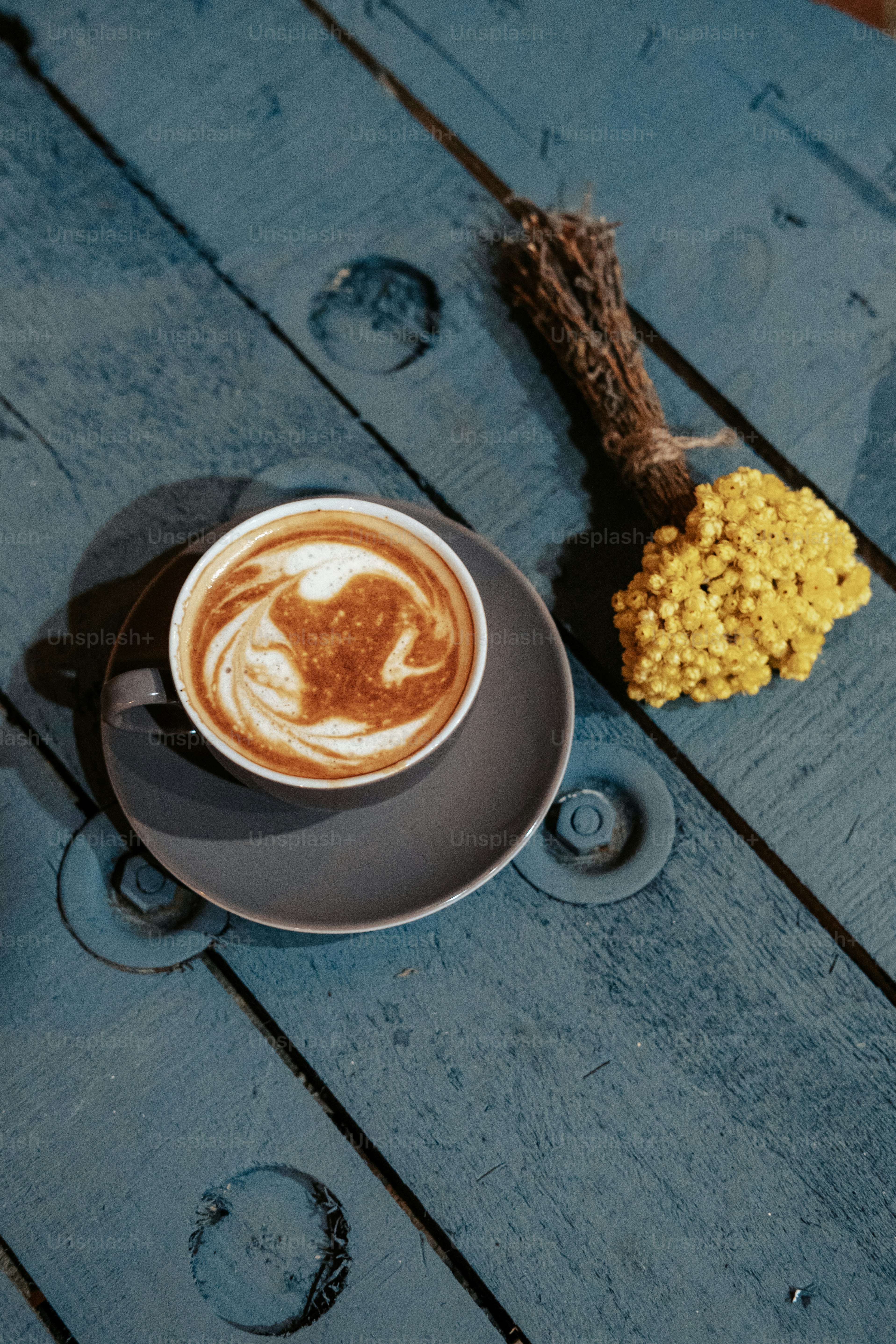 a cup of cappuccino on a saucer on a wooden table