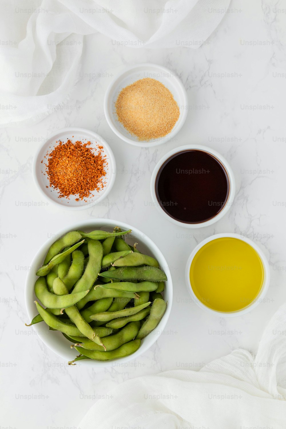 a white table topped with bowls filled with green beans