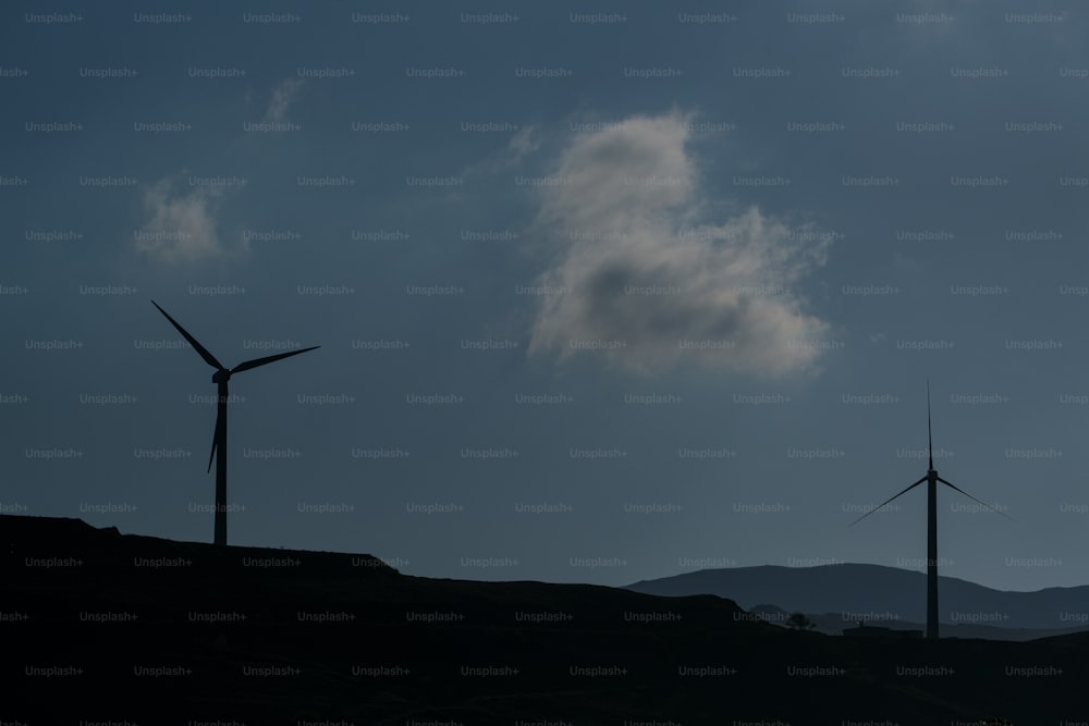 a couple of windmills that are on a hill