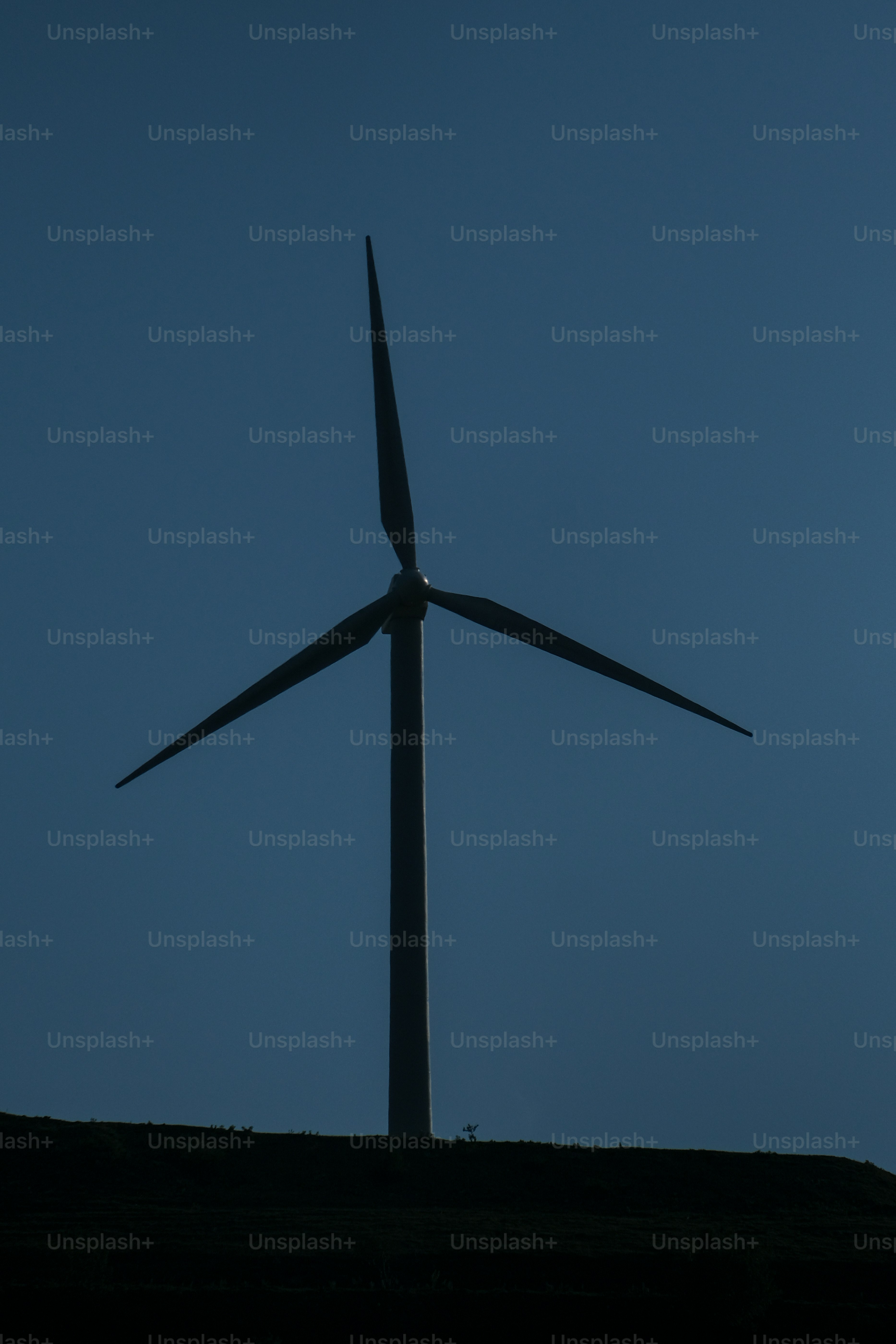 a large wind turbine on top of a hill