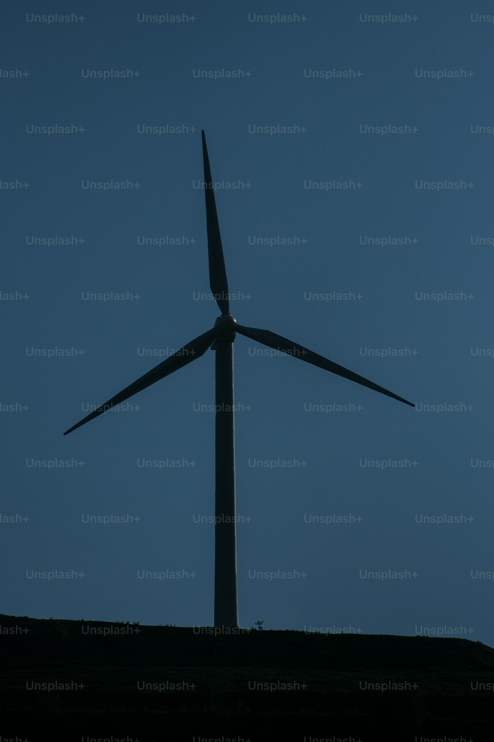 a large wind turbine on top of a hill