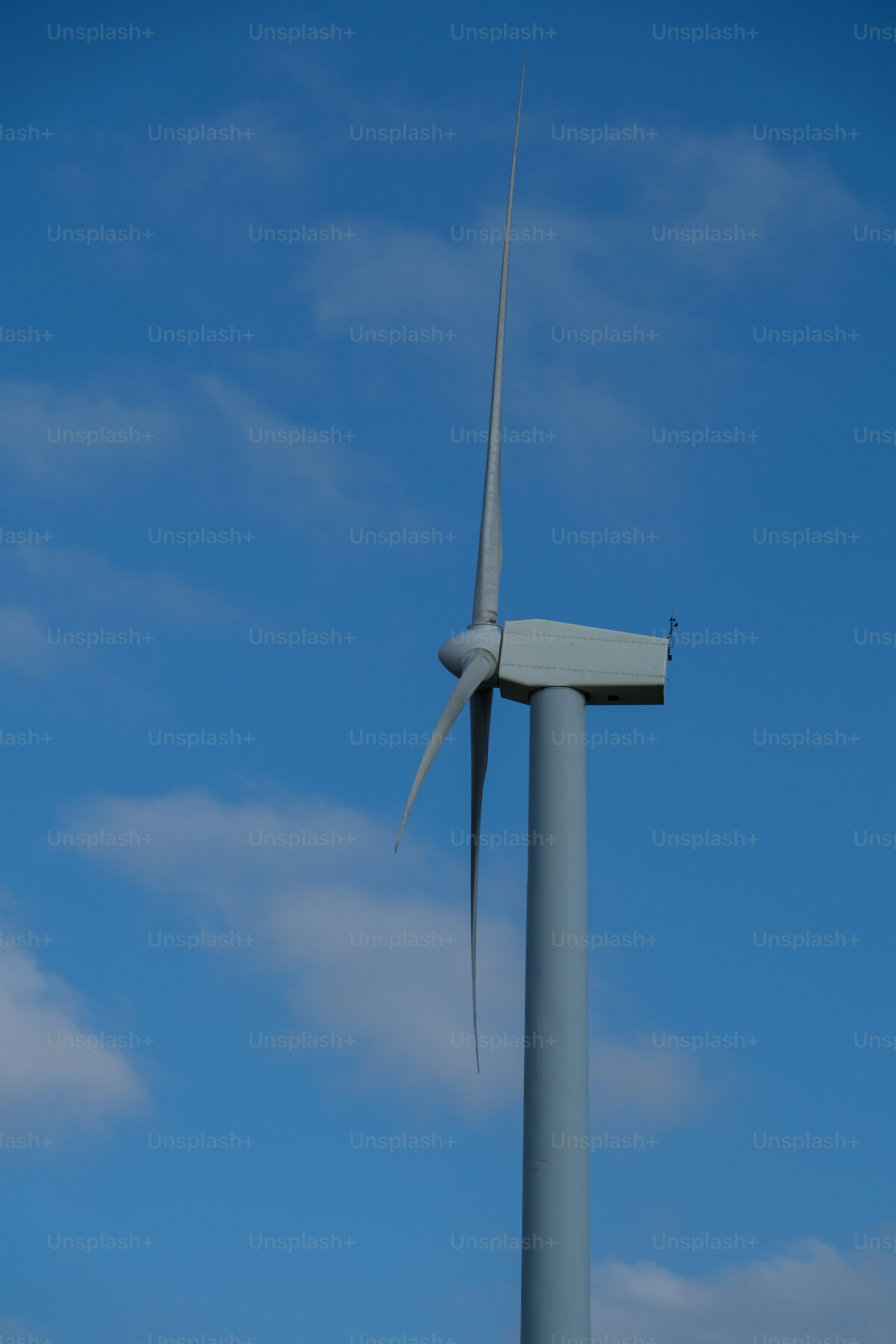 a wind turbine with a blue sky in the background