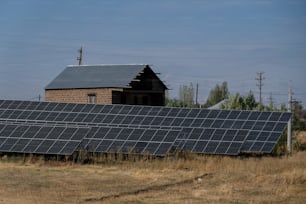 a row of solar panels in front of a barn