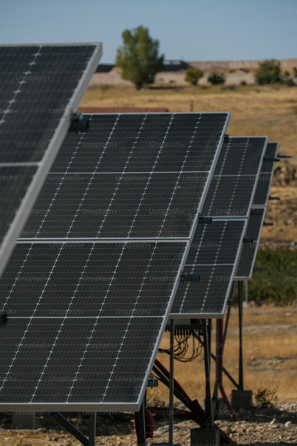 a row of solar panels sitting on top of a dry grass field
